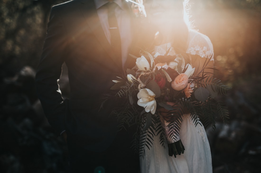 Two hands joined at a wedding, sepia-toned.